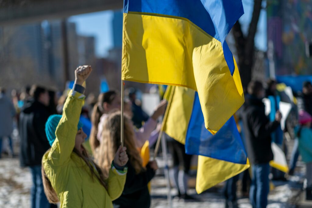Lidé drží ukrajinské vlajky v rukou.