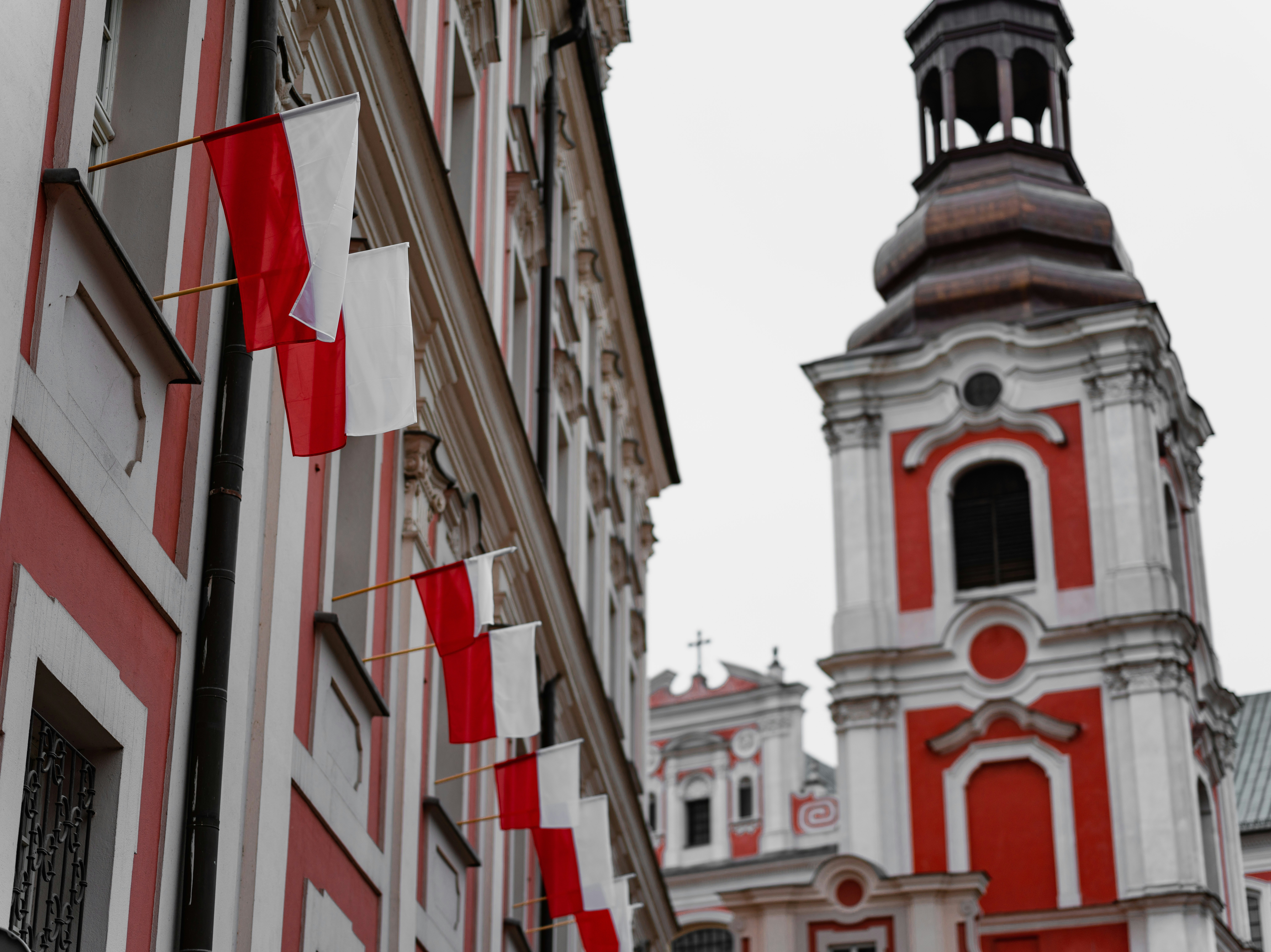 Polská Poznaň s vyvěšenými polskými vlajkami na budovách.